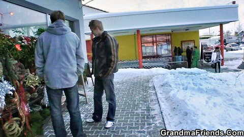 Two guys in winter clothes outside store, picking up mature mom for threesome action