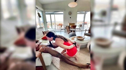 Wife in red dress performs BDSM oral tease on husband's thigh
