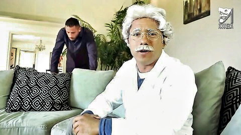 Einstein lookalike in lab coat on couch with suited man, aphrodisiac tea setup