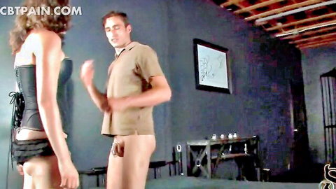 Mistress Tatjana in corset tortures man's exposed cock