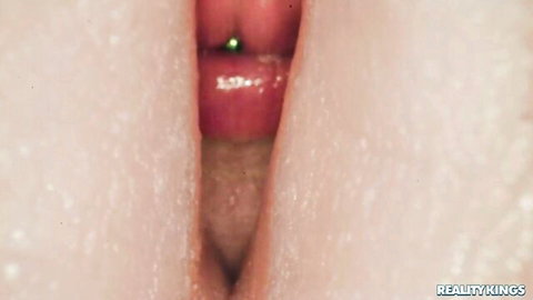 Close-up of shaved pink pussy lips spread wide open with green clit piercing visible