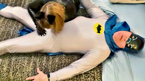 Granny Catwoman in black latex costume teases Batman's costumed crotch in superhero cosplay