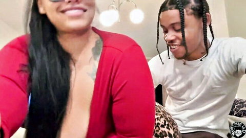 Curvy ebony BBW in red open cardigan with smiling black man, teasing cleavage
