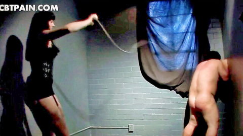 Amateur BDSM: dominant woman in black dress whips naked muscular man in cock torture scene