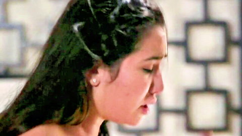 Close-up of emotional young Asian woman with long dark hair looking distressed with teary eyes