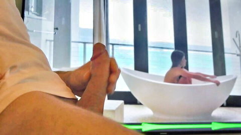 Man jerking erect cock while watching nude brunette in bathtub