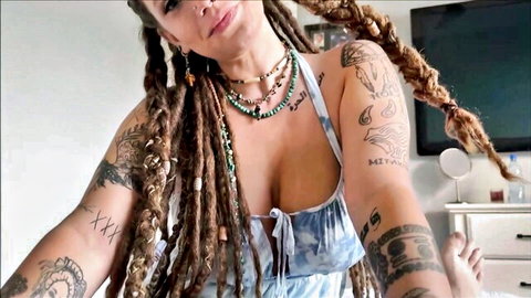 Busty tattooed dreadlock babe with huge cleavage in low-cut tied top selfie