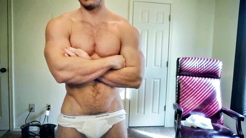 Muscular shirtless man in white briefs, confident pose