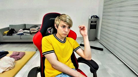 Blonde twink in yellow shirt sitting casually in gay porn video