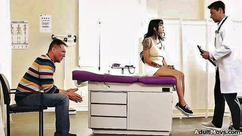 Tattooed brunette patient sits spread-legged on exam table with doctor and DILF stepdad watching