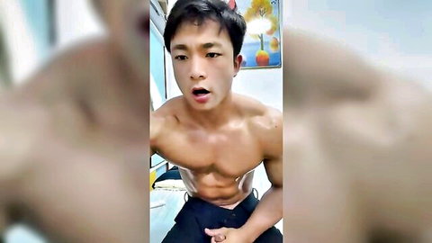 Muscular Korean stud with ripped abs teases hard cock bulge through shorts in webcam solo