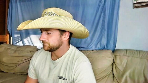 Bearded cowboy hunk in straw hat lounging shirtless on couch webcam tease