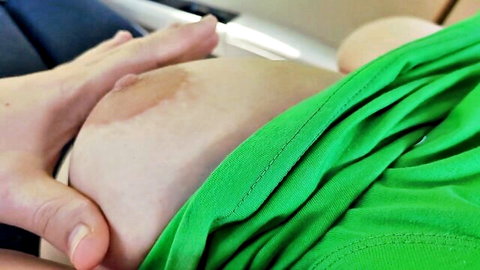 Pregnant babe lifting green shirt exposing bare swollen belly with stretch marks in car