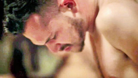Intense bearded man grimacing with bare chest and furrowed brows close-up