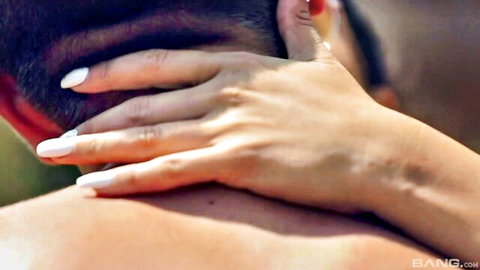Woman's hands with long white nails gripping tanned man's neck from behind passionately