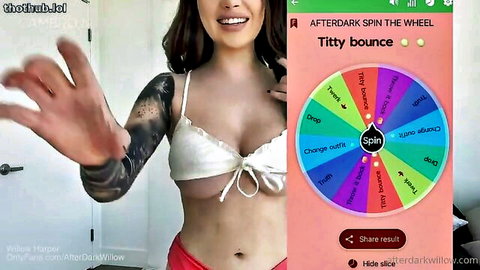 Tattooed babe flashes huge bare tits smiling while spinning titty bounce wheel