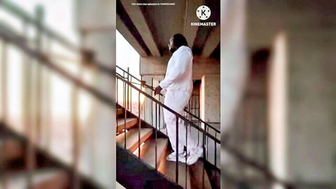 Ebony woman in flowing white outfit ascending stairs at sunset, teasing preview