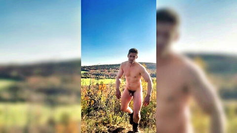 Muscular Caucasian man posing nude outdoors in scenic field, solo exhibition
