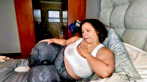 Ebony BBW with big tits gropes her breast while fingering pussy inside leggings on bed