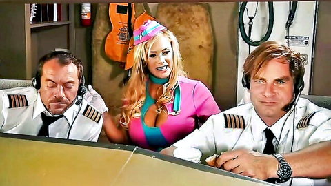 Busty blonde flight attendant in pink uniform with two pilots in cockpit
