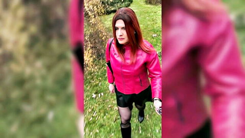 Redhead in pink leather jacket, black miniskirt, stockings and boots in garden