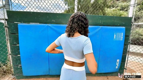 Isabella Jules Latina in blue crop top and shorts, curly hair, rear view