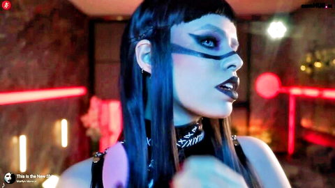 Alessa Goreng in goth makeup, black harness and choker, seductive pose