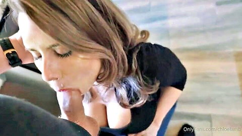 Chloe Lamb close-up blowjob on man, cleavage in black top, brunette model
