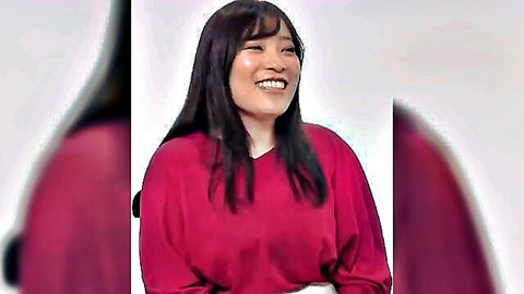 Smiling East Asian beauty with long dark hair in loose red blouse teasing her curves