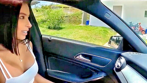 Colombian teen in white crop top showing cleavage, smiling in car