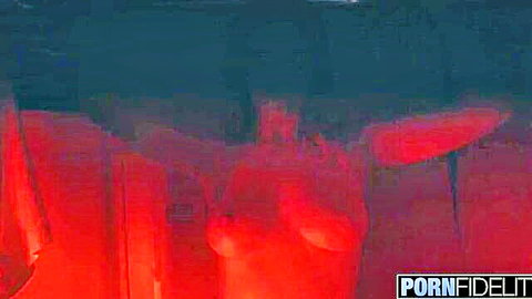 Melody Marks topless with arms raised in erotic red-lit scene