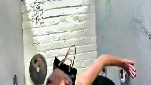Babe's arm with purse extends through gloryhole in graffiti brick wall