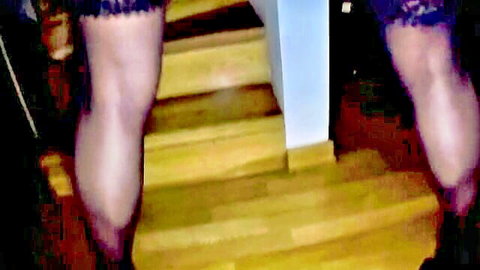 Woman's sexy long legs in black lace stockings teasing on wooden stairs