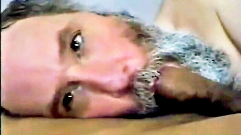 Closeup of hairy gray-bearded DILF lying nude looking at camera