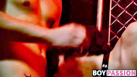 Muscular top fucks bottom's ass doggystyle gripping hips in red-lit cage gay sex