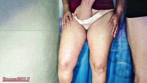 Curvy woman pulling down panties to pee while getting pissed on by partner in shower