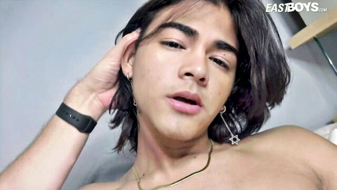 Shirtless young Latino twink with long hair in teasing pose, first handjob scene