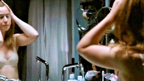 Blonde with small tits in sheer lace bra scratches head in bathroom mirror
