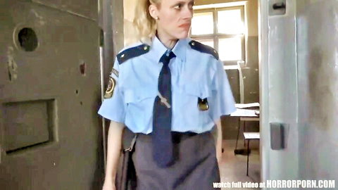 Blonde policewoman in uniform standing in doorway, stern expression