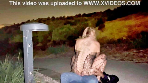 Blonde call girl in lace lingerie and fishnets teasing on street at night
