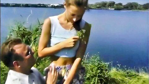 Busty blonde in tank top and skirt teases man by lake before hot blowjob