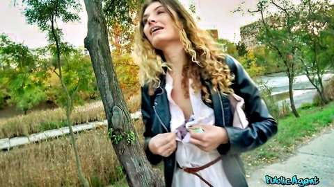 Curly blonde babe flashing deep cleavage in leather jacket holding cash outdoors for Public Agent