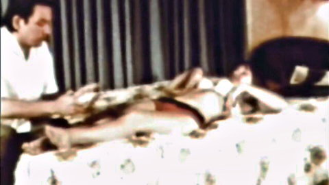 Vintage mature brunette MILF lies naked legs spread as man fingers her exposed pussy on bed