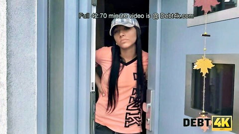 Brunette girl in pink tank top stands seductively in doorway for debt sex payment
