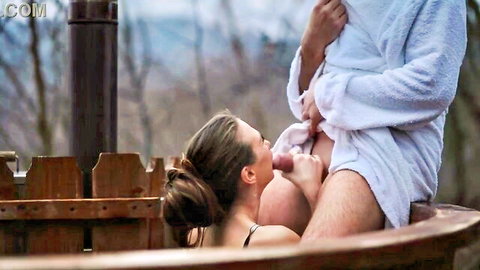 Brunette babe in outdoor hot tub grips and strokes man's erect cock from open white bathrobe