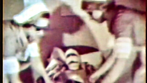 Vintage nurses in masks examine patient's spread legs in retro medical fetish scene