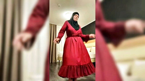 Fatima dancing seductively in red hijab dress in hotel room
