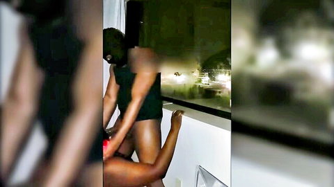 Ebony man dominates curvy black woman in doggy style against night window