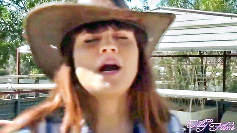 Redhead cowgirl with hat moaning passionately in outdoor sapphic sex scene