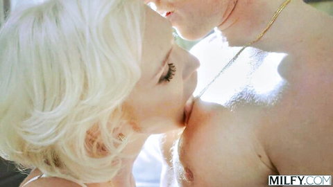 Blonde bombshell passionately kissing muscular stud's neck in intimate closeup